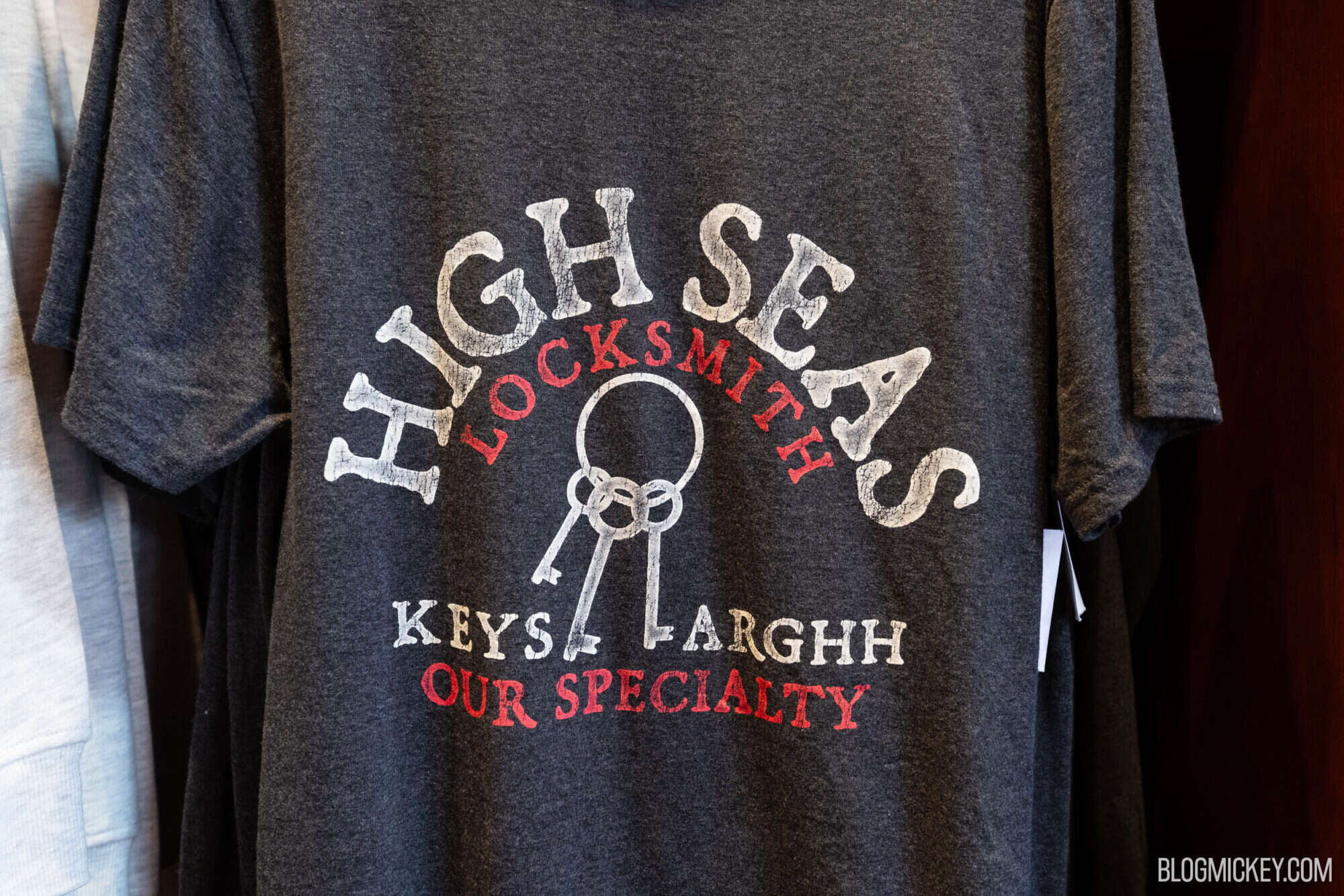 Vintage-inspired dark gray T-shirt with a keys graphic and retro typography, celebrating a locksmith's craft at Disney World. Perfect for fans of themed apparel and Disney souvenir shirts.
