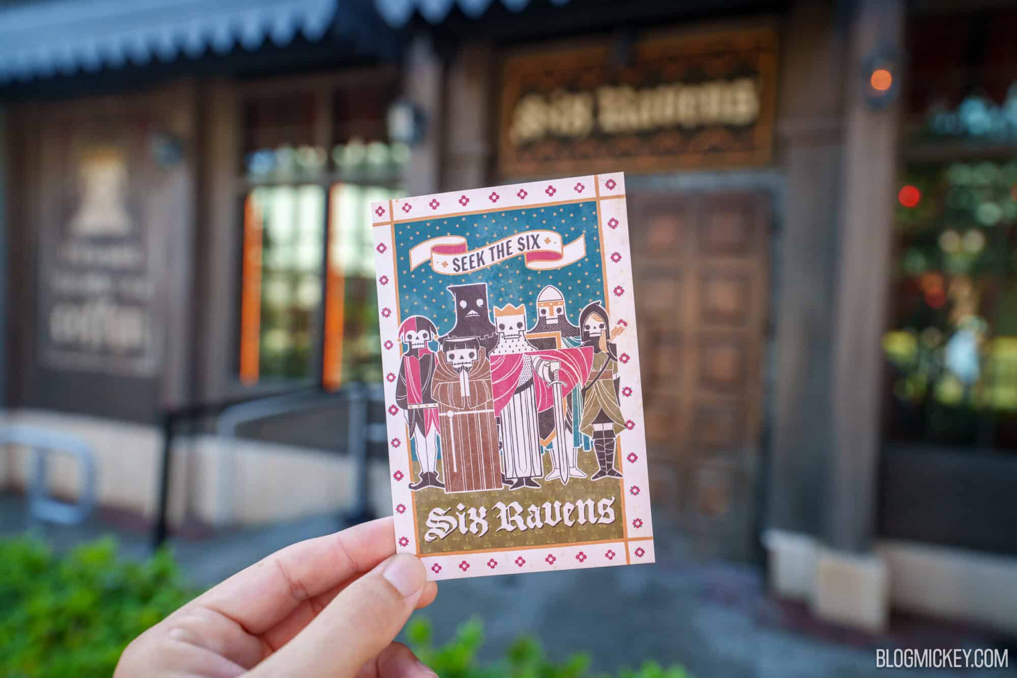 Hand holding a Six Ravens card outside Disney Springs.