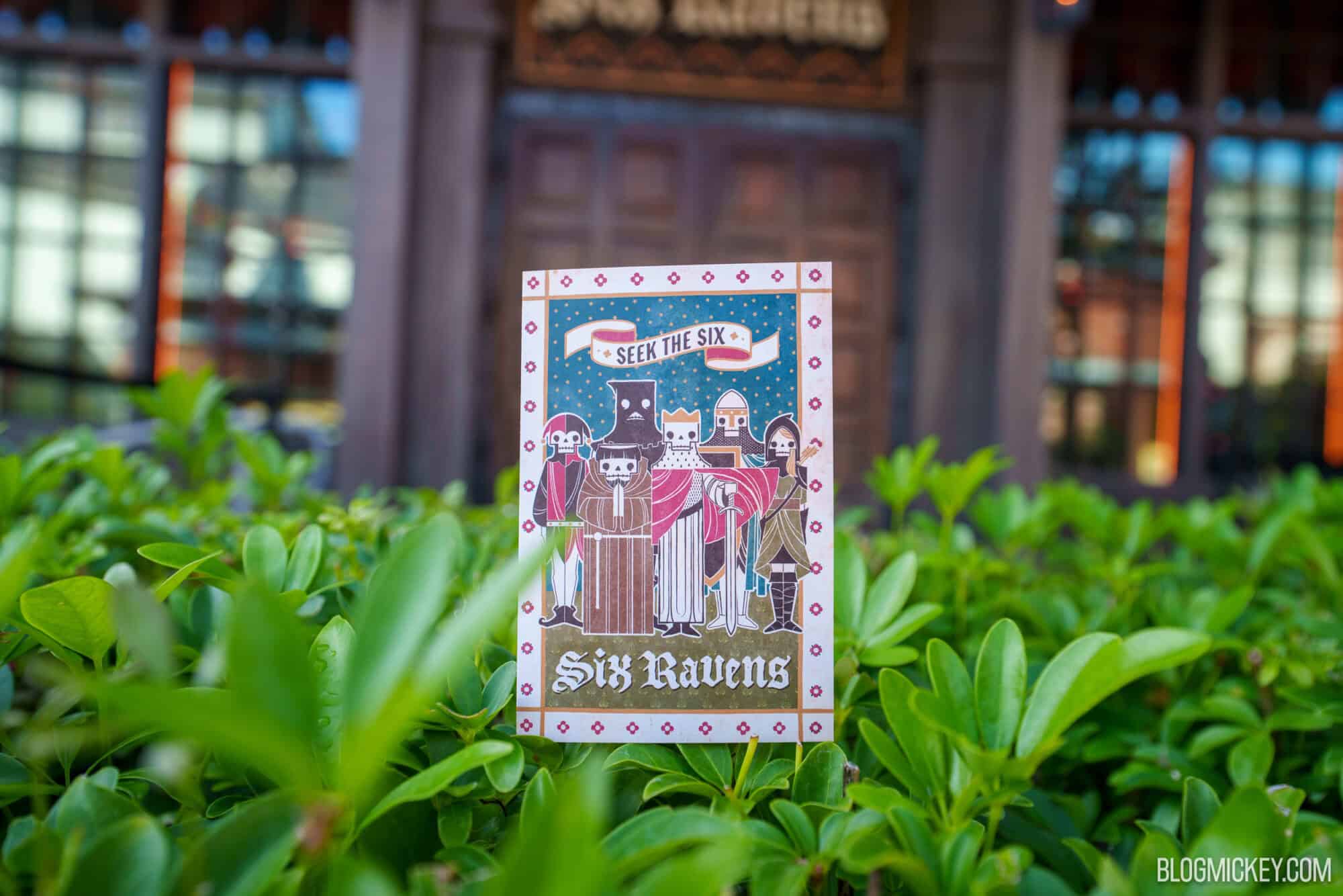 Colorful Six Ravens sign at Disney Springs with greenery in foreground.