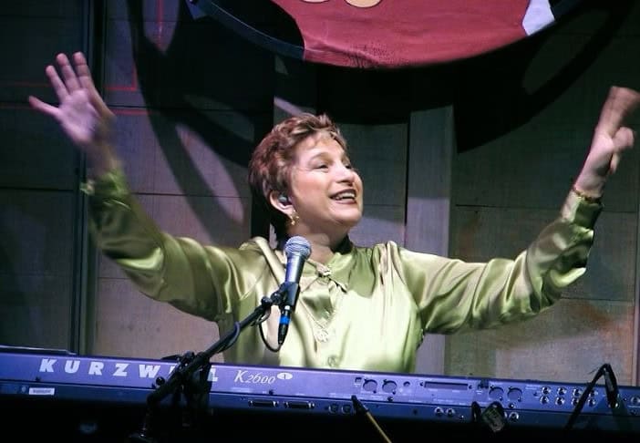 Carol smiling at the piano.