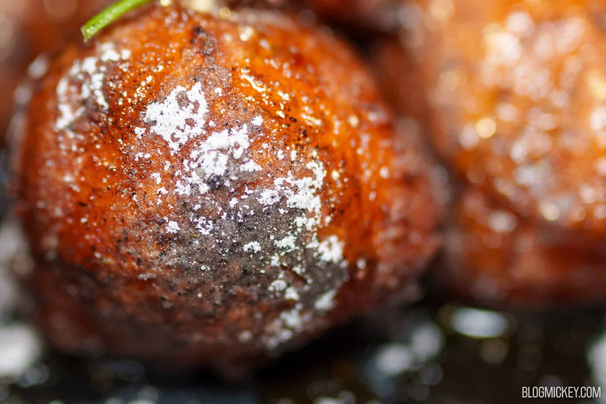 Close-up of fried dough balls dusted with powdered sugar at Magic Kingdom.