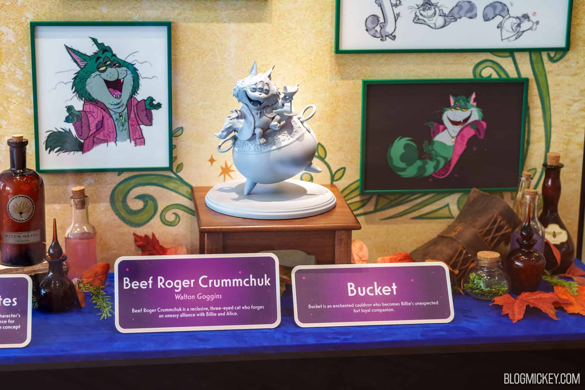 Disney World themed display with character maquettes and framed art.