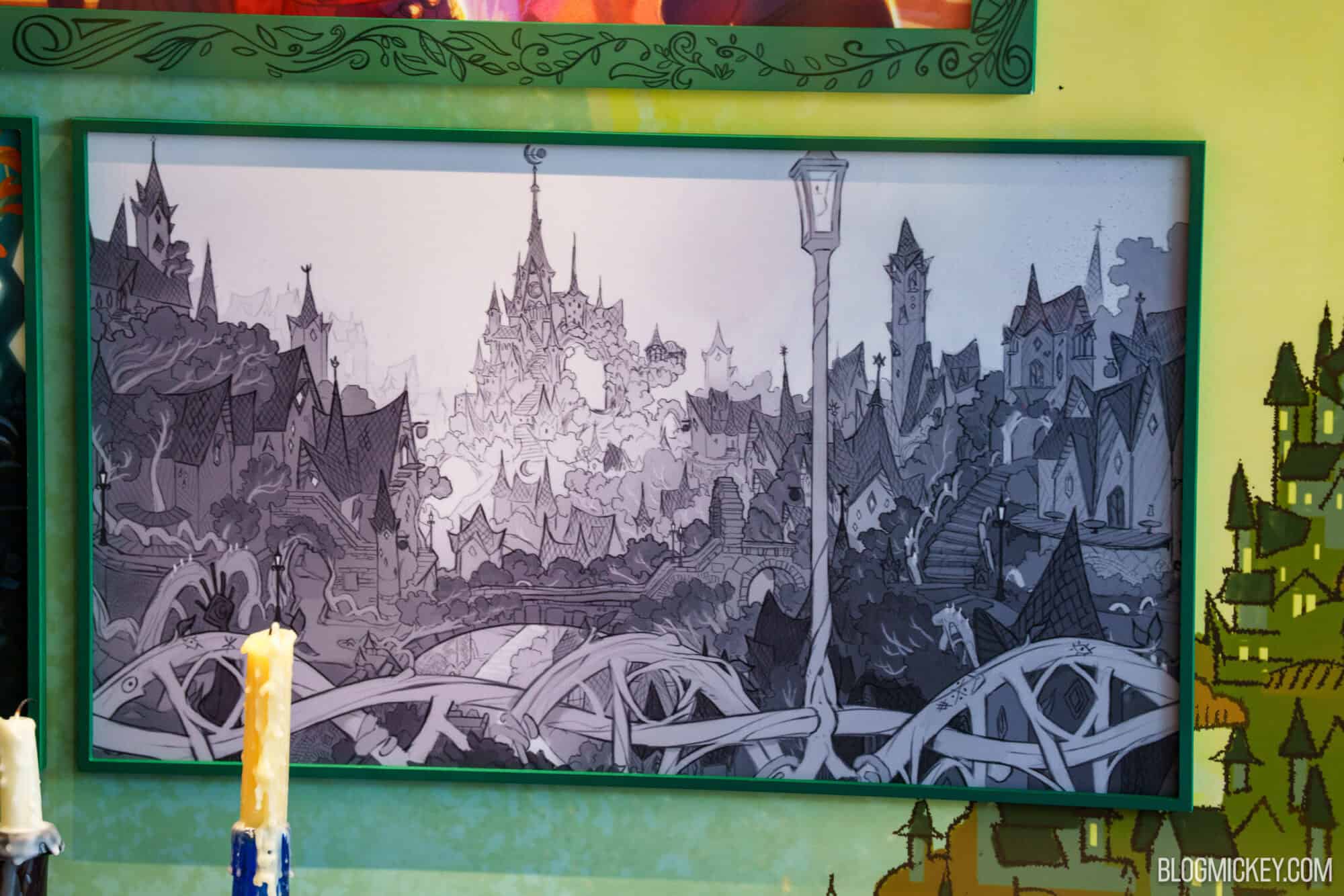 Framed concept art showcasing intricate maquettes and fantasy cityscape at Hollywood Studios.